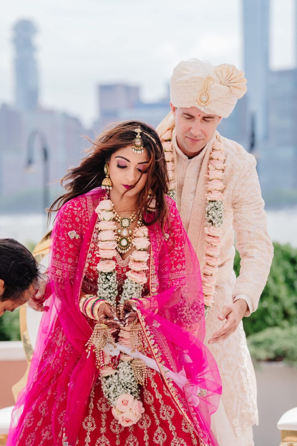 Bride in pink lehenga with groom in ivory sherwani