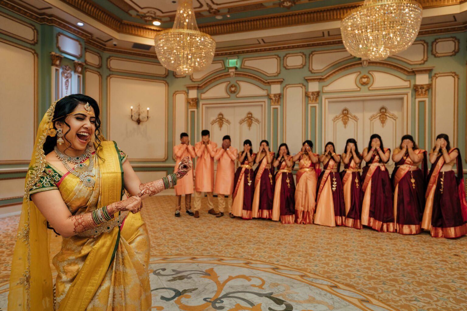 Bride laughing with friends in yellow saree