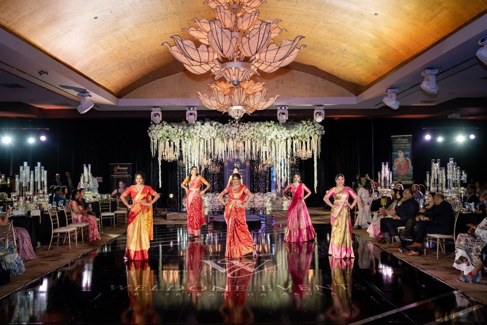 Ballroom runway show in red sarees
